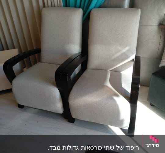 שני כורסאות מרופדות בבד בהיר עם ידיות עץ כהות